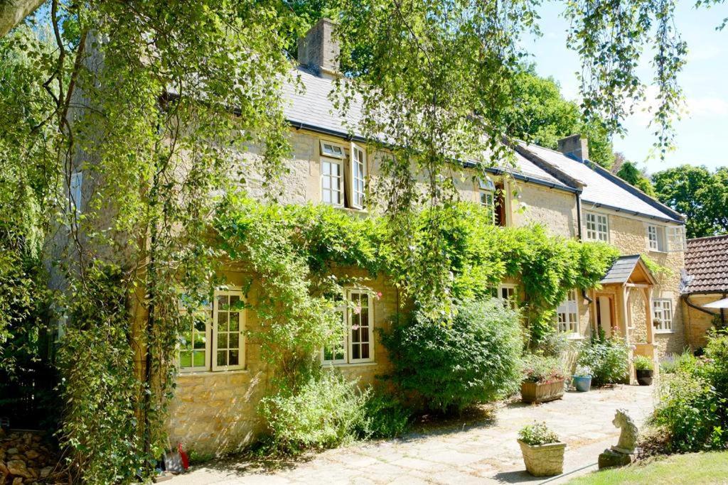 Una casa con hiedra a un lado. en Bagnell Farm Cottage en Chiselborough