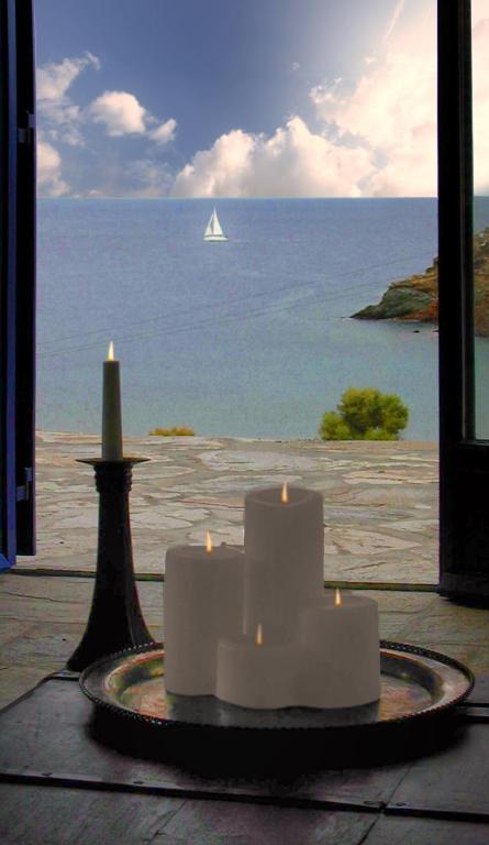 two candles on a table with a view of the ocean at Amelia Beachfront Villa in Korissia