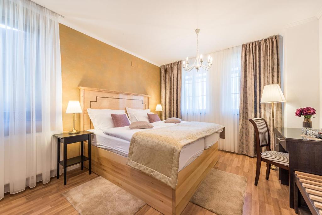 una camera d'albergo con letto, scrivania e finestre di Plitvice Falls Cottage a Plitvica Selo