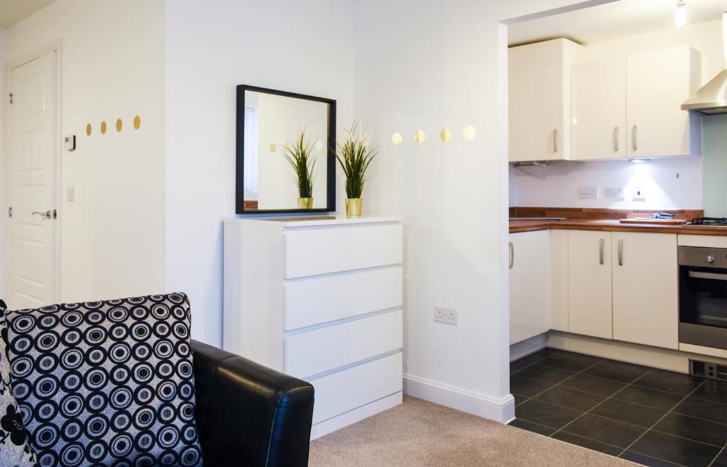 a kitchen with white cabinets and a black chair at 1 Bedroom Apartment Leamington Spa Hosted By Golden Key in Warwick