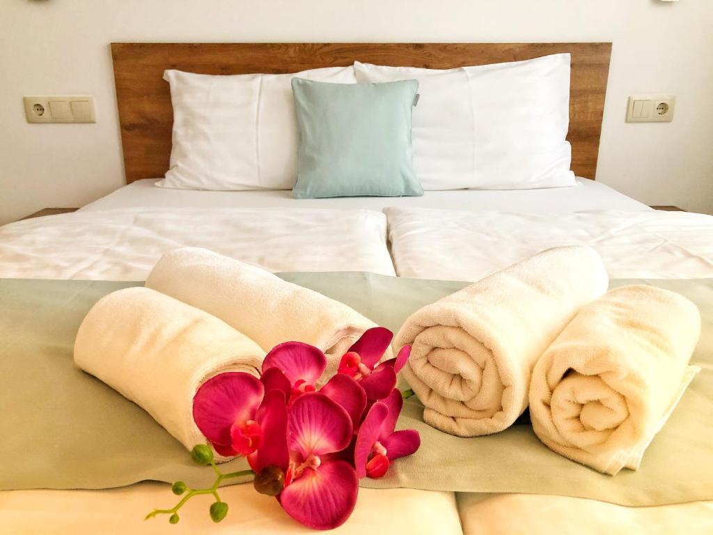 a bed with towels and flowers on top of it at Boró Apartman in Tiszafüred