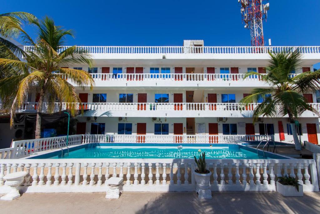 a hotel with a swimming pool in front of a building at Hotel Boquilla Suites By GEH Suites in Cartagena de Indias