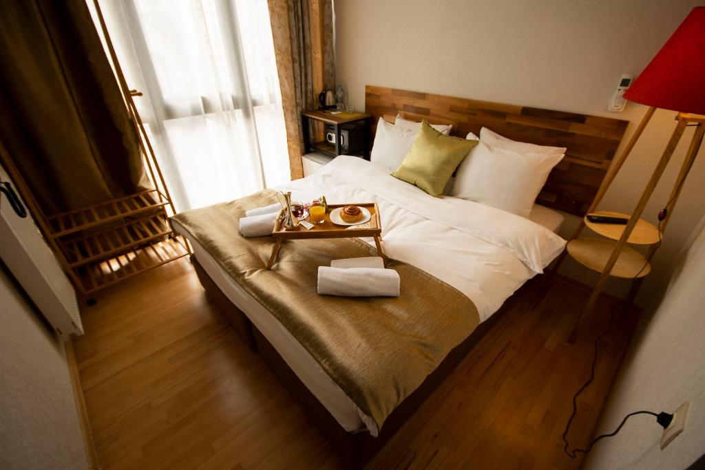 a bedroom with a bed with a tray of food on it at Hotel Cordata in Tbilisi City