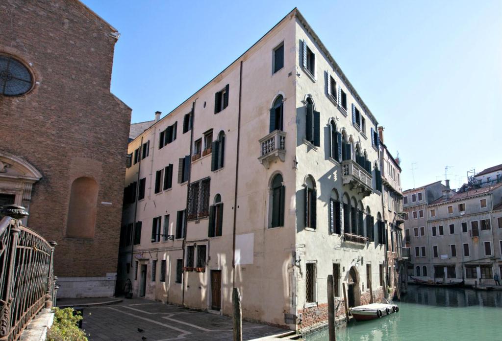 um edifício antigo ao lado de um canal em Residence Ca' Foscolo em Veneza