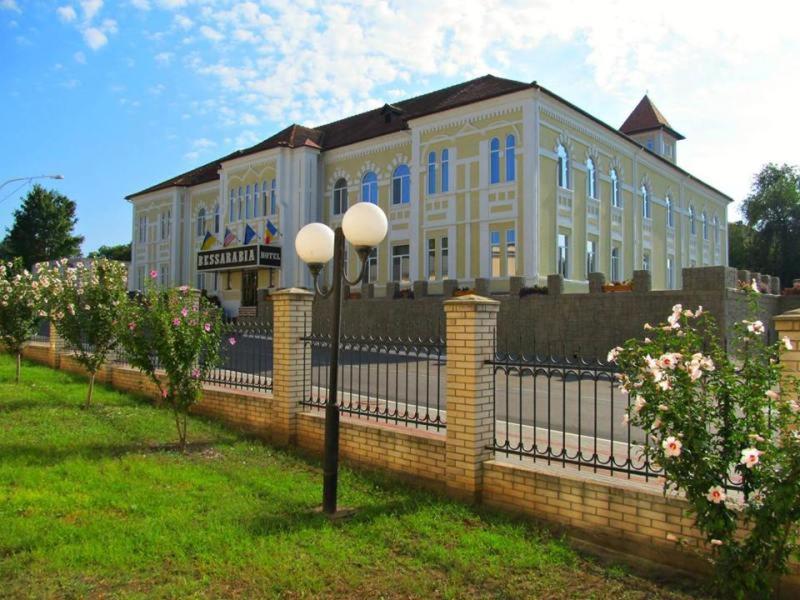 un grand bâtiment avec une clôture devant lui dans l'établissement Отель БЕССАРАБИЯ, à Izmaïl
