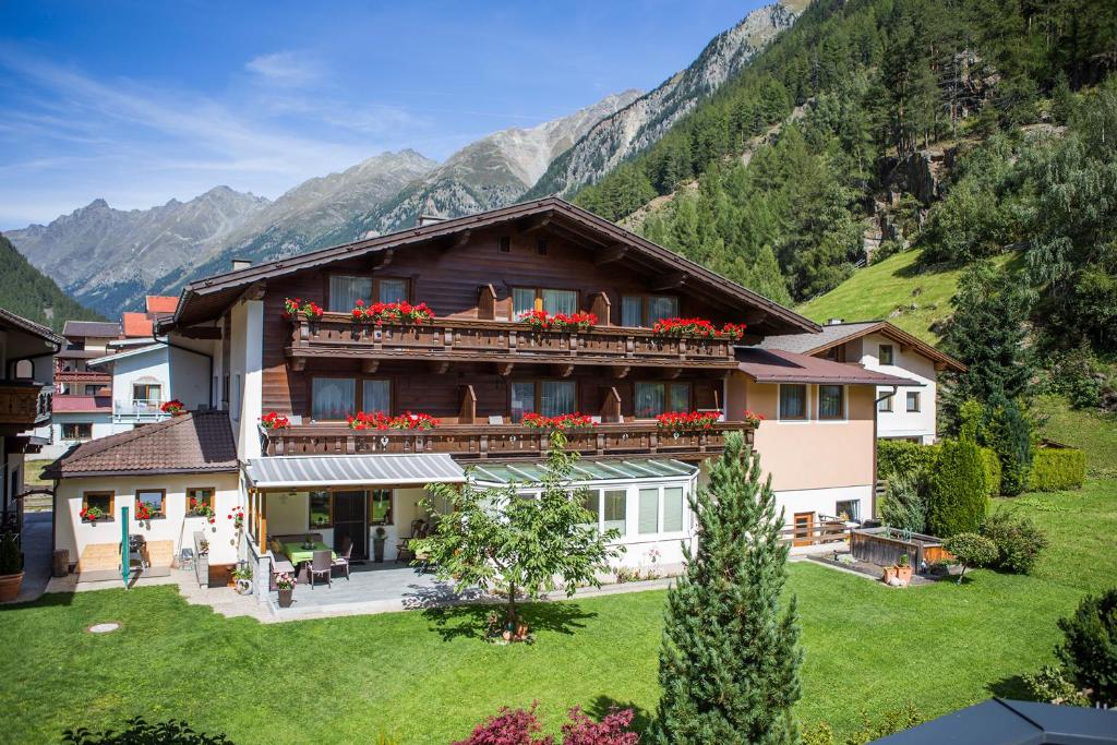 a house with a balcony with red flowers on it at Sportpension Rubin in Sölden