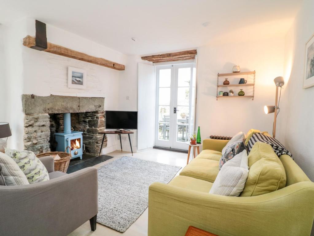 a living room with a couch and a fireplace at 1 Jubilee Cottage in Tintagel