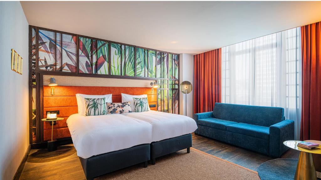
a hotel room with a large bed and a large window at Hotel Indigo Brussels - City, an IHG Hotel in Brussels
