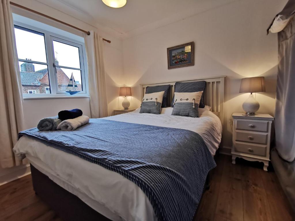 a bedroom with a large bed with a dog laying on it at AnchorageWells Holiday Cottage and King Ensuites Room Only in Wells next the Sea