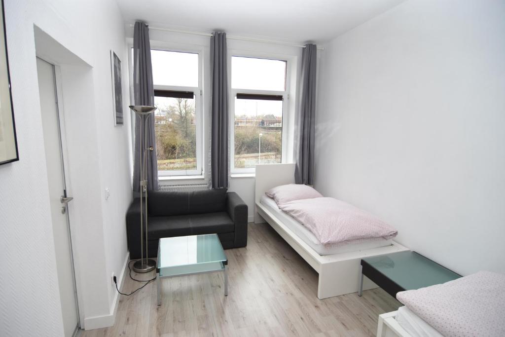 a bedroom with a bed and a chair and a window at City Apartment Vohwinkel in Gelsenkirchen