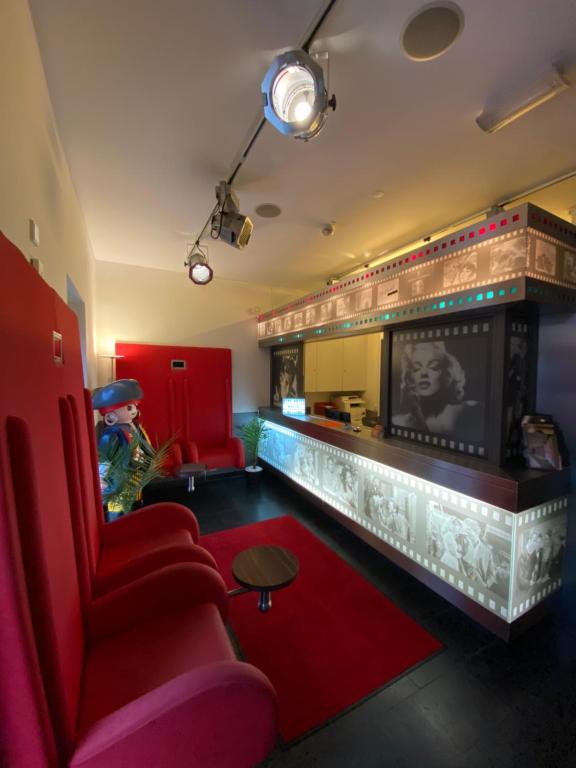 ツィルンドルフにあるCineHotel Maroniのリビングルーム(赤いソファ、暖炉付)