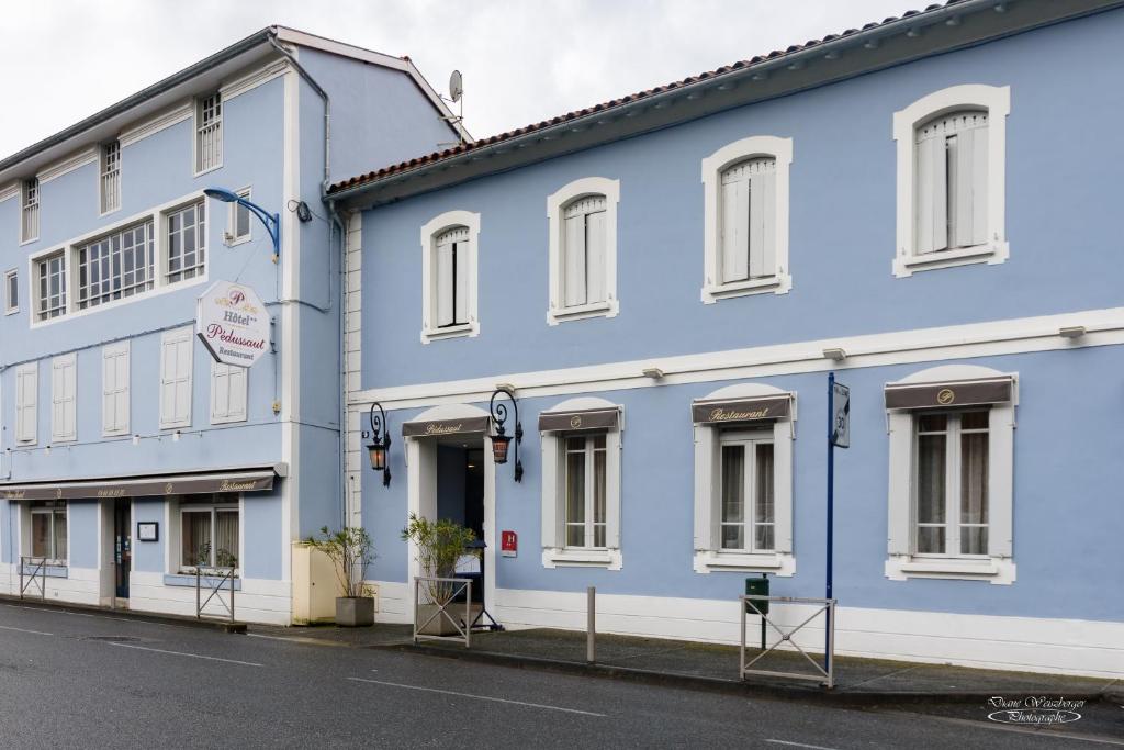 a blue building on the side of a street at Hôtel Pedussaut in Saint-Gaudens