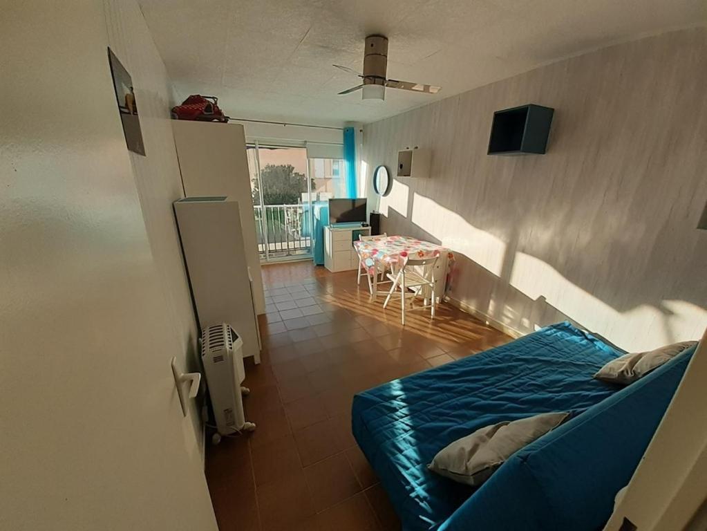 une pièce avec un lit et une table dedans dans l'établissement AS18262 - Studio en Centre Ville, au Grau-du-Roi