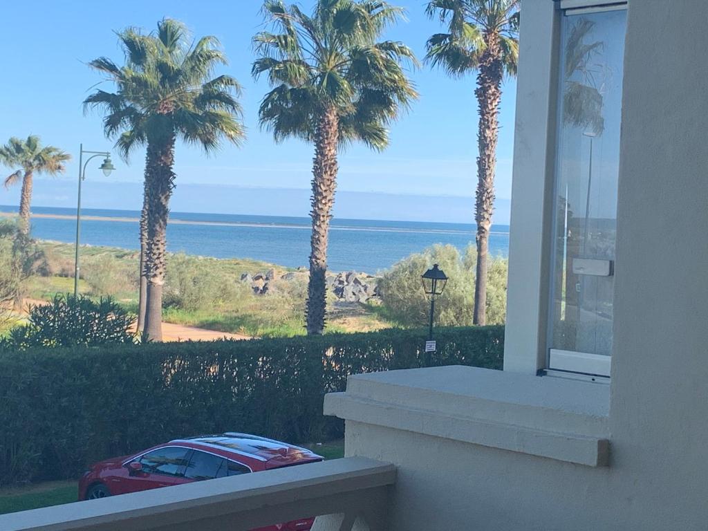 einen Blick auf das Meer von einem Haus mit Palmen in der Unterkunft Primera Linea de Playa con Vistas al Mar in Isla Canela