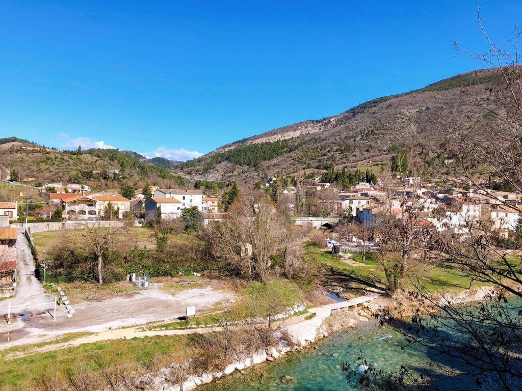 a small town on a hill next to a river at Le Rieussec in Saillans