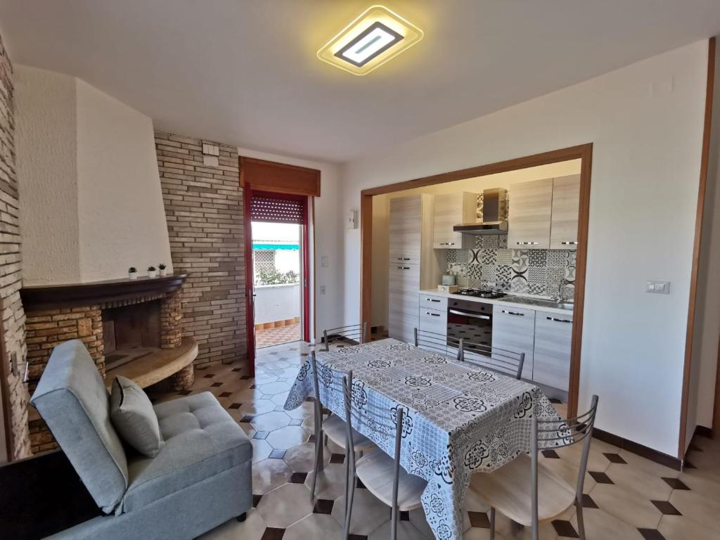 a kitchen and dining room with a table and a couch at Villa Boito in Marina di Pescoluse
