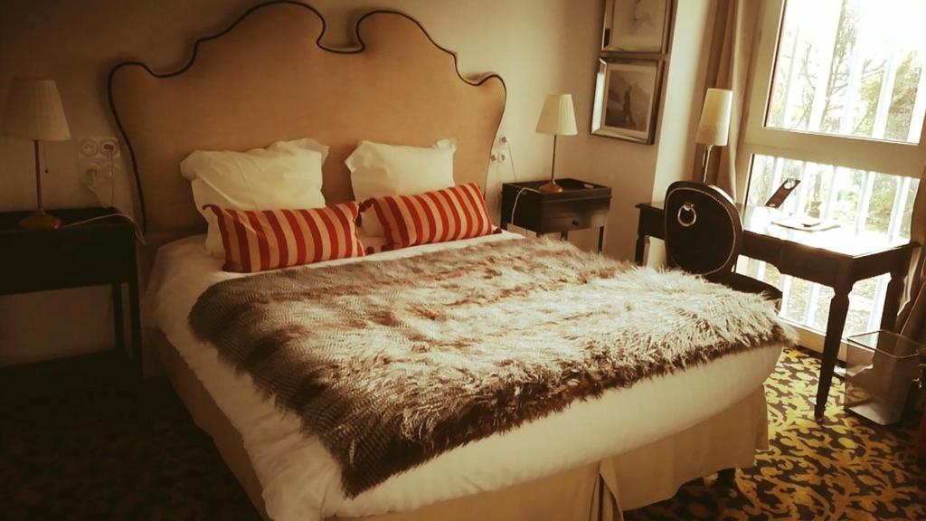 een slaapkamer met een groot bed met rode kussens bij Mercator in Vendôme