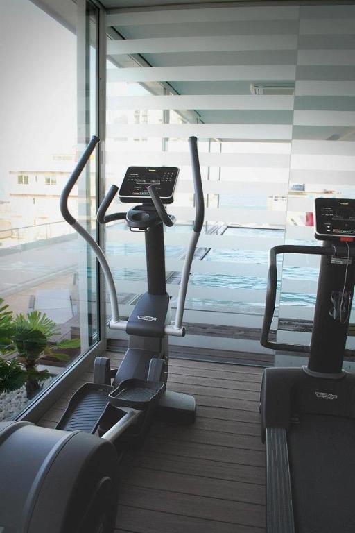 a gym with two exercise bikes in a room with a window at Il Teatro in Lido di Jesolo