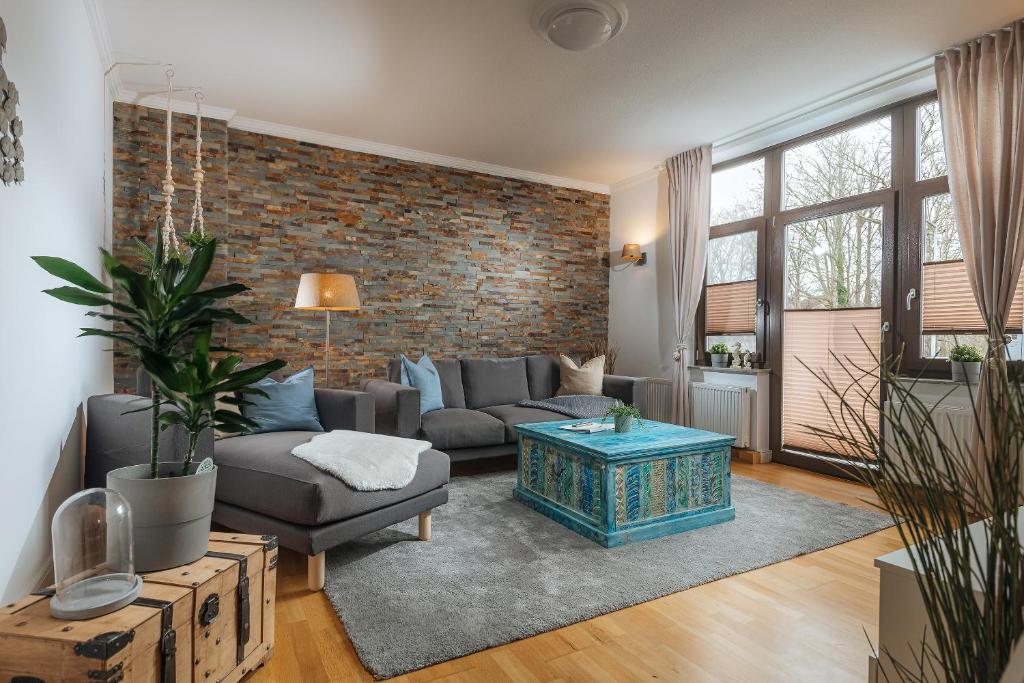 - un salon avec un canapé et un mur en briques dans l'établissement Große Koje mit Terrasse, à Rostock