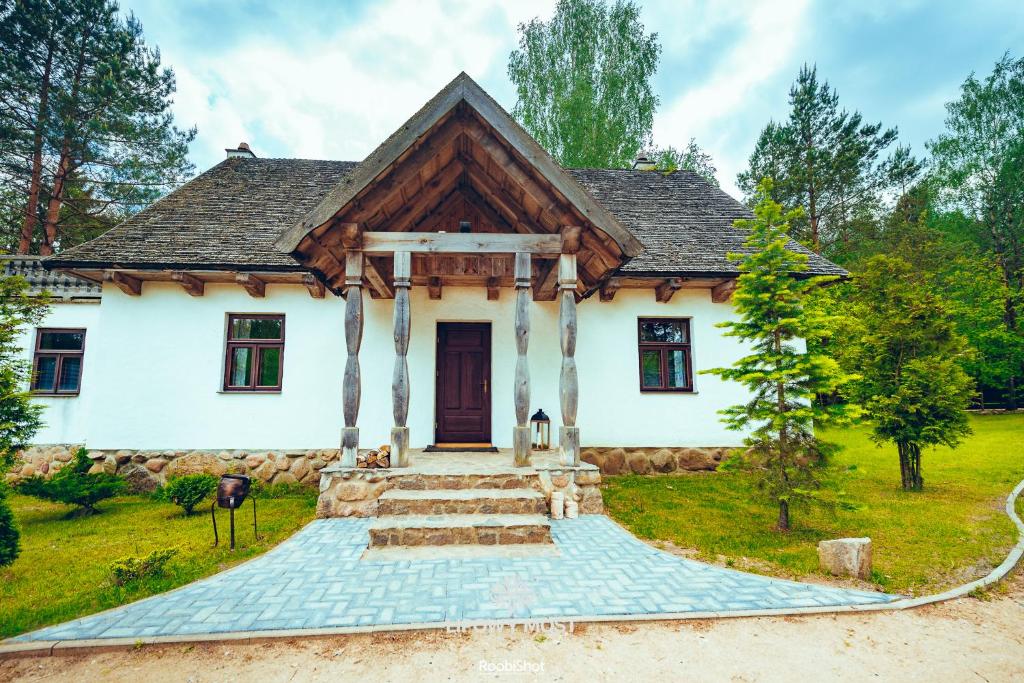 uma casa branca com um telhado de gambrel em Domek Lipowy Most em Supraśl