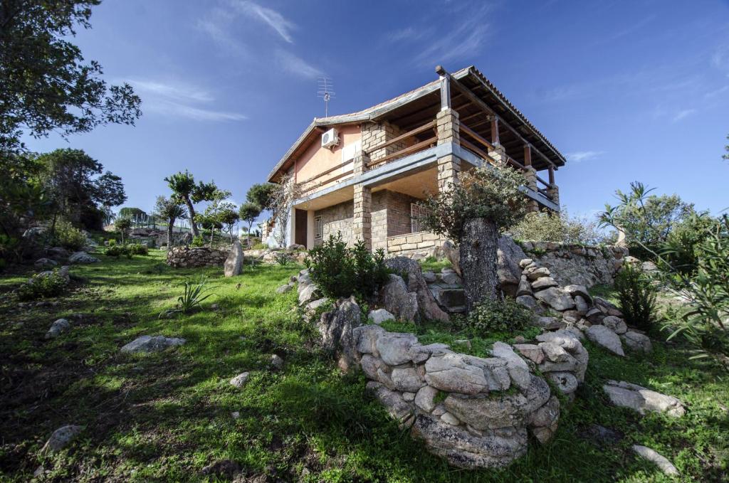 una casa con una pared de piedra delante de ella en Villa Unica - Appartamenti Alba e Tramonto, en Isola Rossa