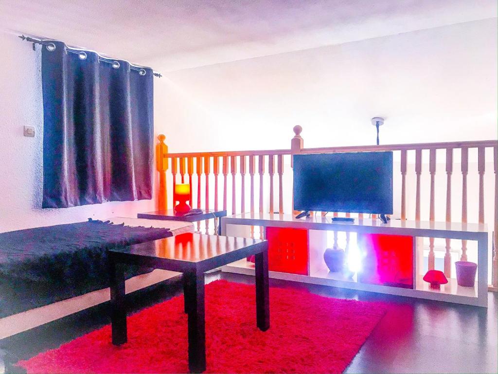 - un salon avec une table et un tapis rouge dans l'établissement Boost Your Immo Duplex Les Deux Alpes 272, à Les Deux Alpes