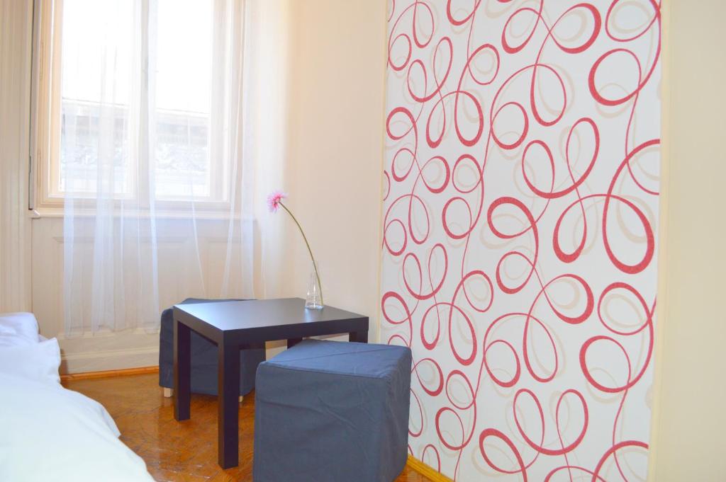 a room with a bed, a table, and a painting on the wall at Synagogue View Guest House in Budapest