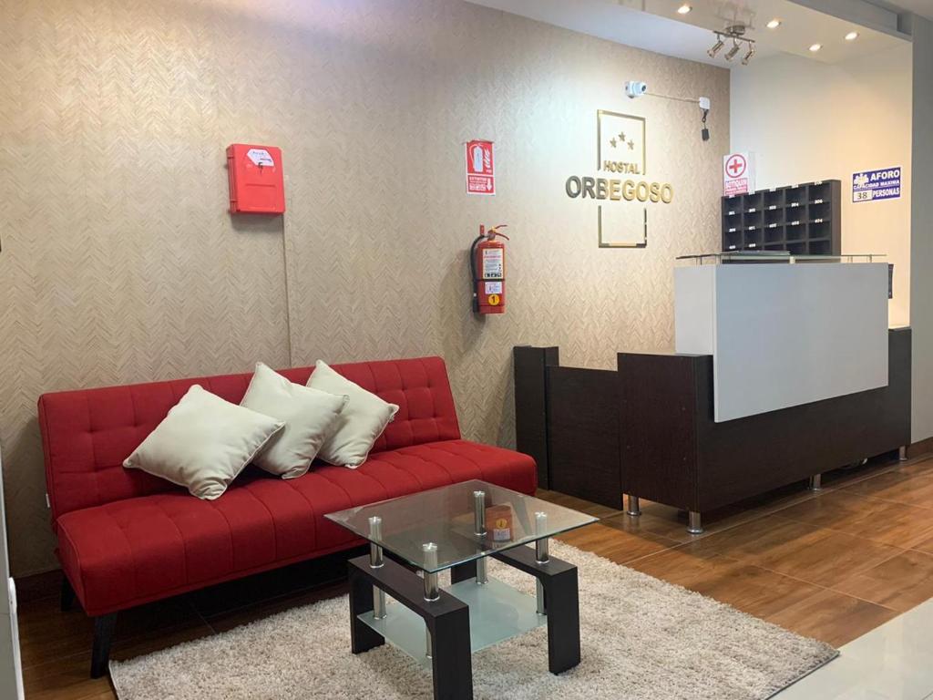 - un salon avec un canapé rouge et une table dans l'établissement ORBEGOSO - Trujillo, à Trujillo