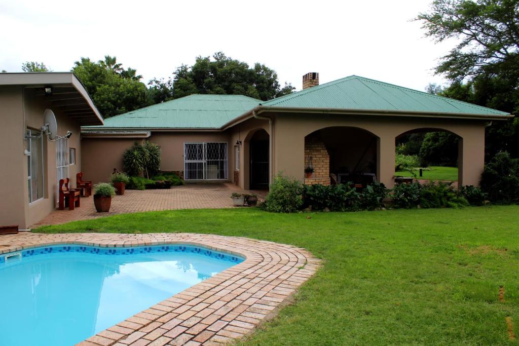 a house with a swimming pool in the yard at Bietjie Rus in Addo