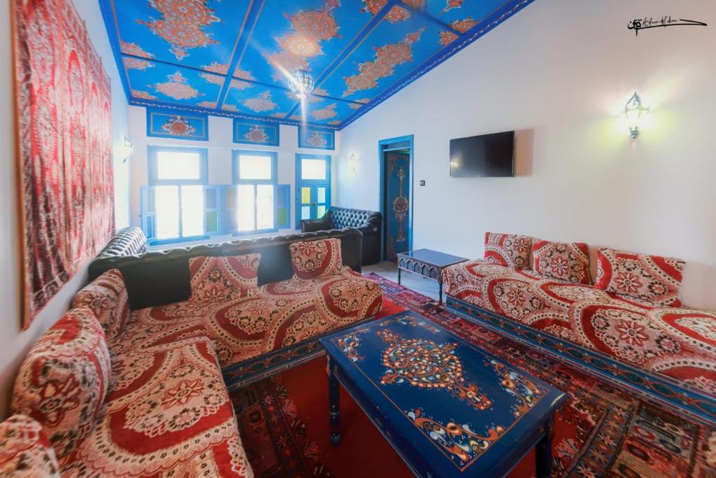 a living room with couches and a blue ceiling at Casa Plasa Grande in Chefchaouen
