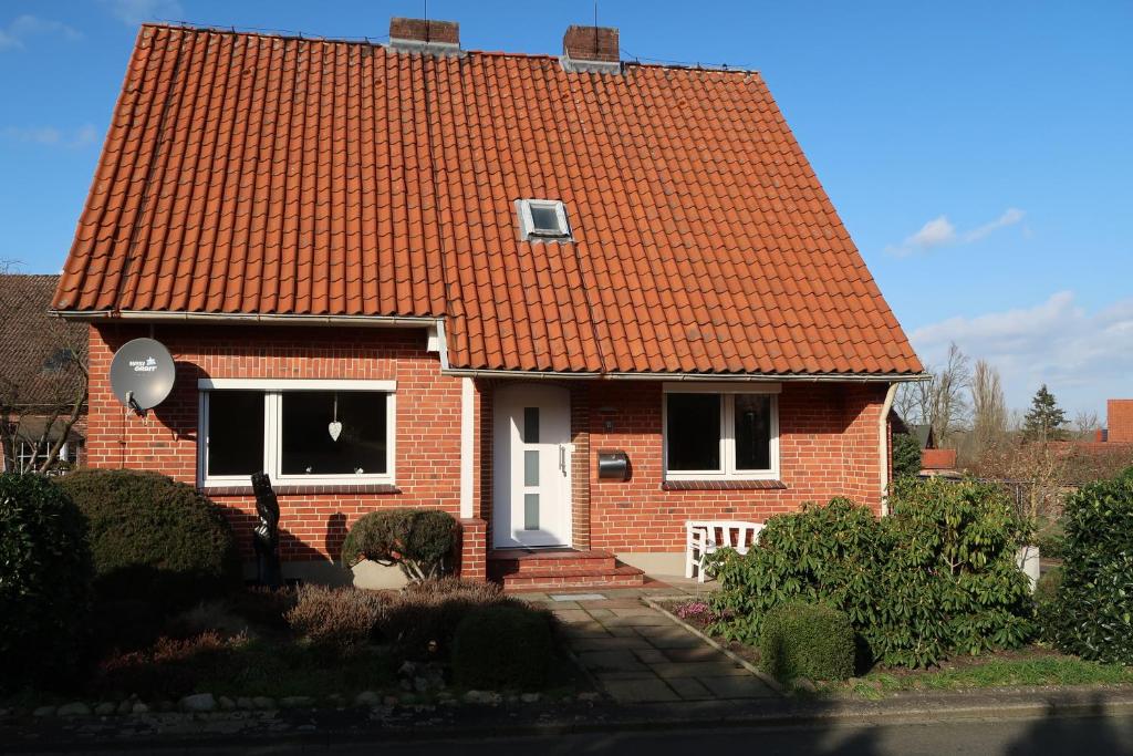 een rood bakstenen huis met een oranje dak bij Ferienwohnung Wildung in Lüneburg