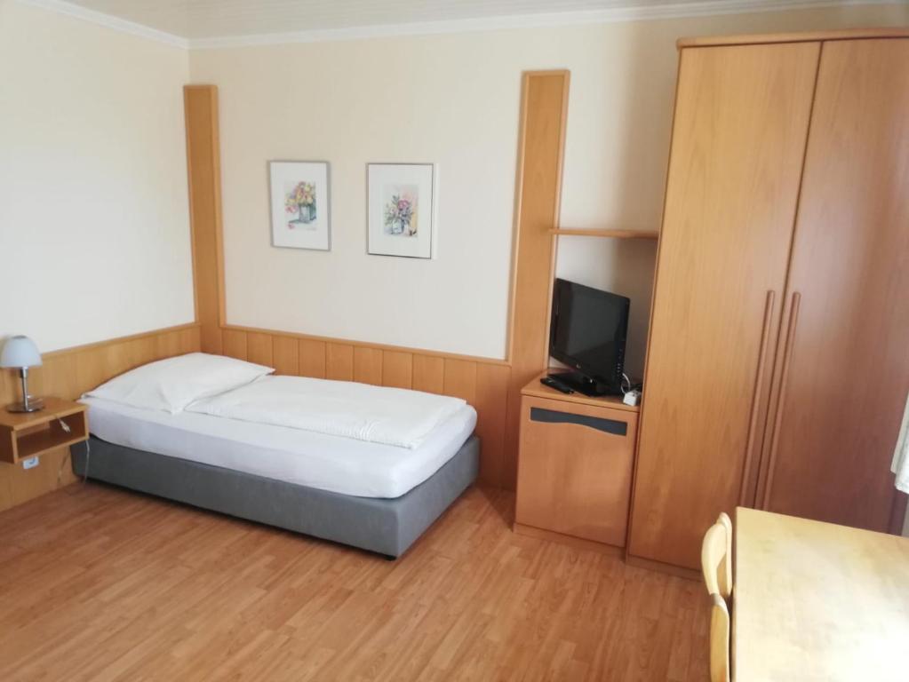 una piccola camera con letto e televisore di Gasthof Kogler-Greisinger a Frankenmarkt