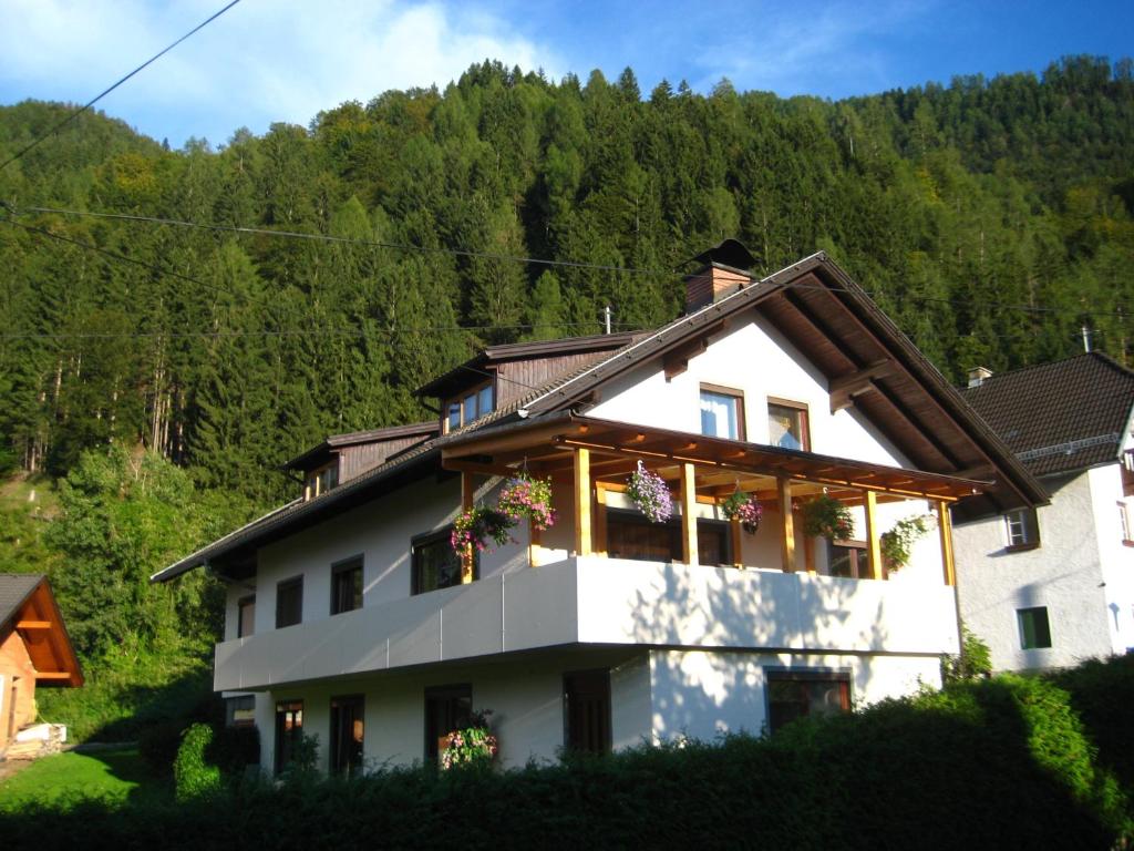 ein weißes Haus mit Blumen in den Fenstern in der Unterkunft Ferienhaus Maier in Lind