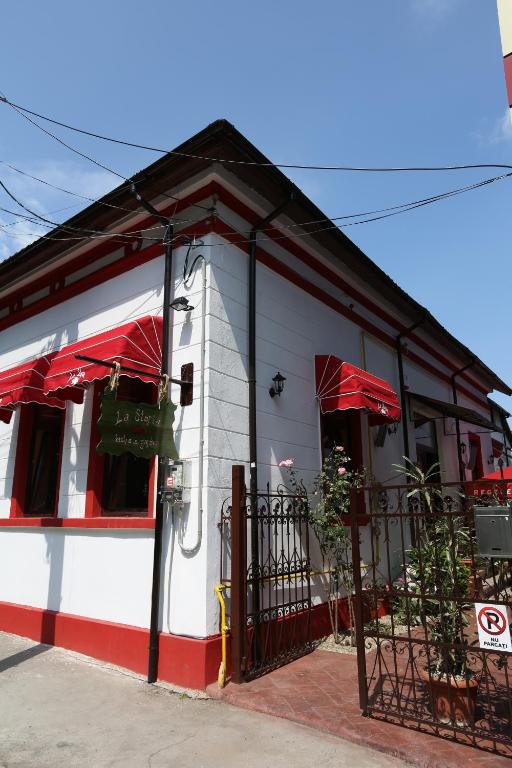 a restaurant with red umbrellas on a street at La Storia Guest House in Piteşti