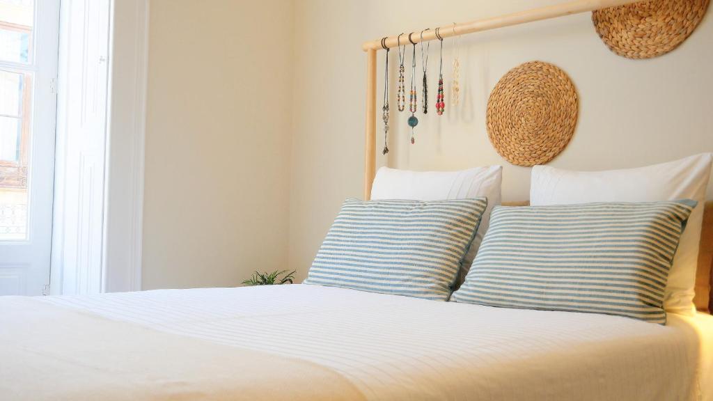 a bedroom with a bed with blue and white pillows at ten2twelve in Espinho