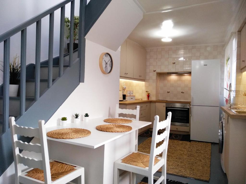 a kitchen with a white table and chairs at Aspa's Traditional House in Plomari