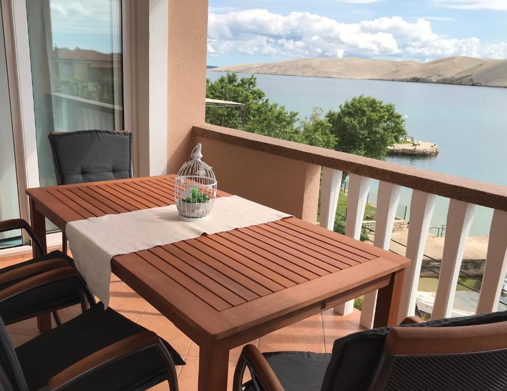 een tafel en stoelen op een balkon met uitzicht op het water bij Apartman Demi in Miškovići