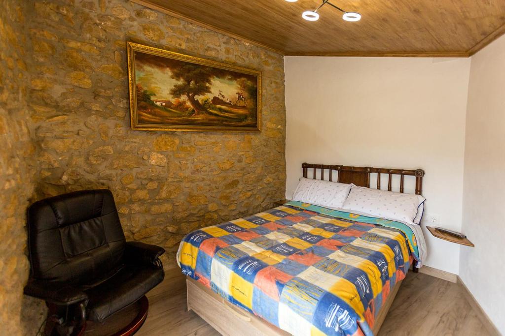 1 dormitorio con 1 cama y 1 silla en Casa Rural La Vinyeta en Ballestar