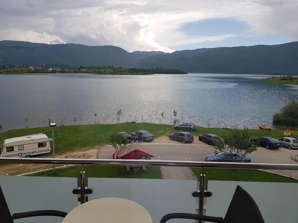 - une vue sur un lac avec des voitures garées et un parking dans l'établissement Mediteran B&B, à Prozor