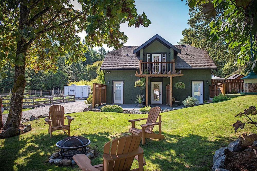 a house with chairs and a fire pit in the yard at Guest suites on Benvenuto in Brentwood Bay