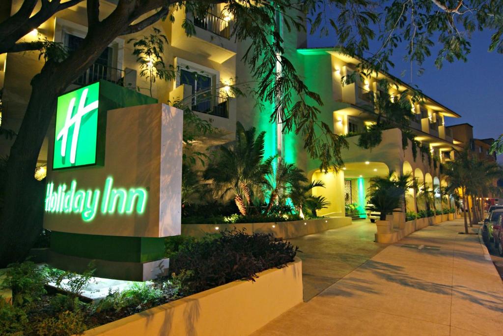 a building with a sign that reads halfway inn at Holiday Inn Huatulco, an IHG Hotel in Santa Cruz Huatulco