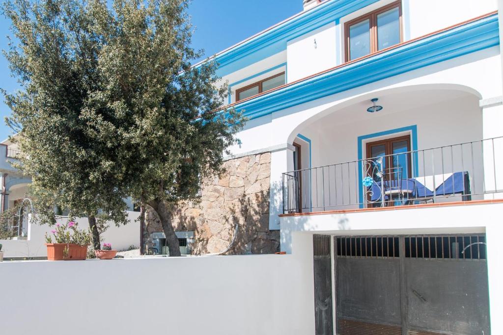 a white house with a gate and a tree at Holiday home in Cala Gonone 34367 in Cala Gonone