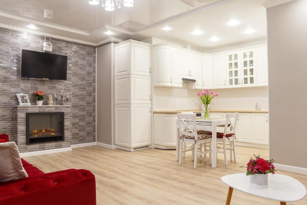VIP- Elite Lemberg Apartments في إلفيف: غرفة معيشة مع طاولة ومدفأة