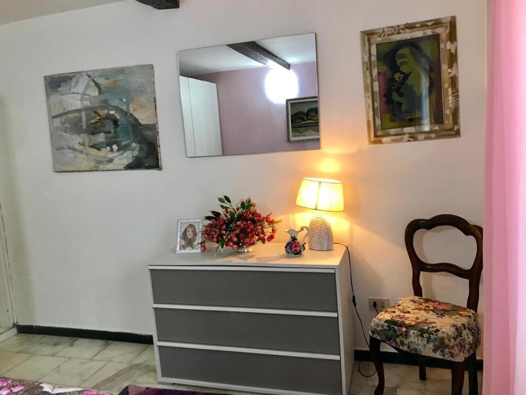 ラ・スペツィアにあるAppartamento Il Soleの室内にランプと椅子付きのドレッサー