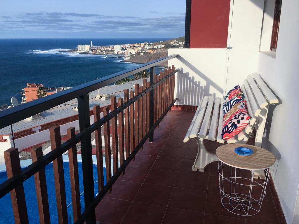 uma varanda com um banco e uma mesa e o oceano em Sunset Dream Bajamar GREAT VIEWS em Baja Mar