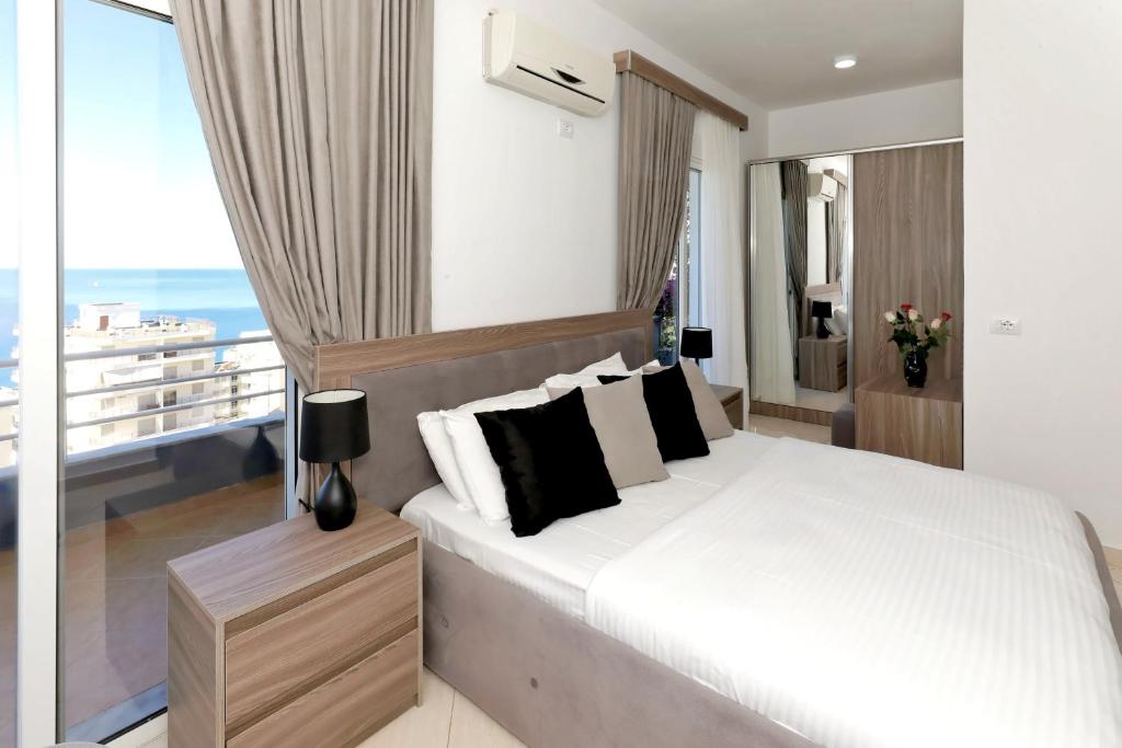 a bedroom with a large bed and a balcony at Villa Doka in Sarandë