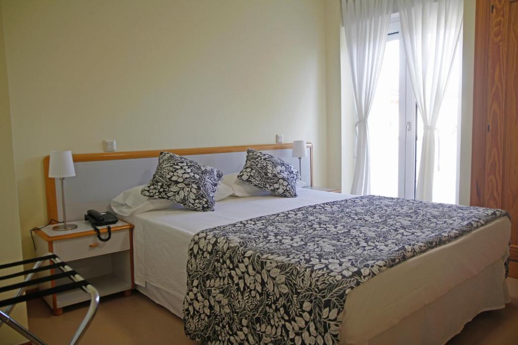 a bedroom with a bed and a window at Hotel Playa de Merón in San Vicente de la Barquera