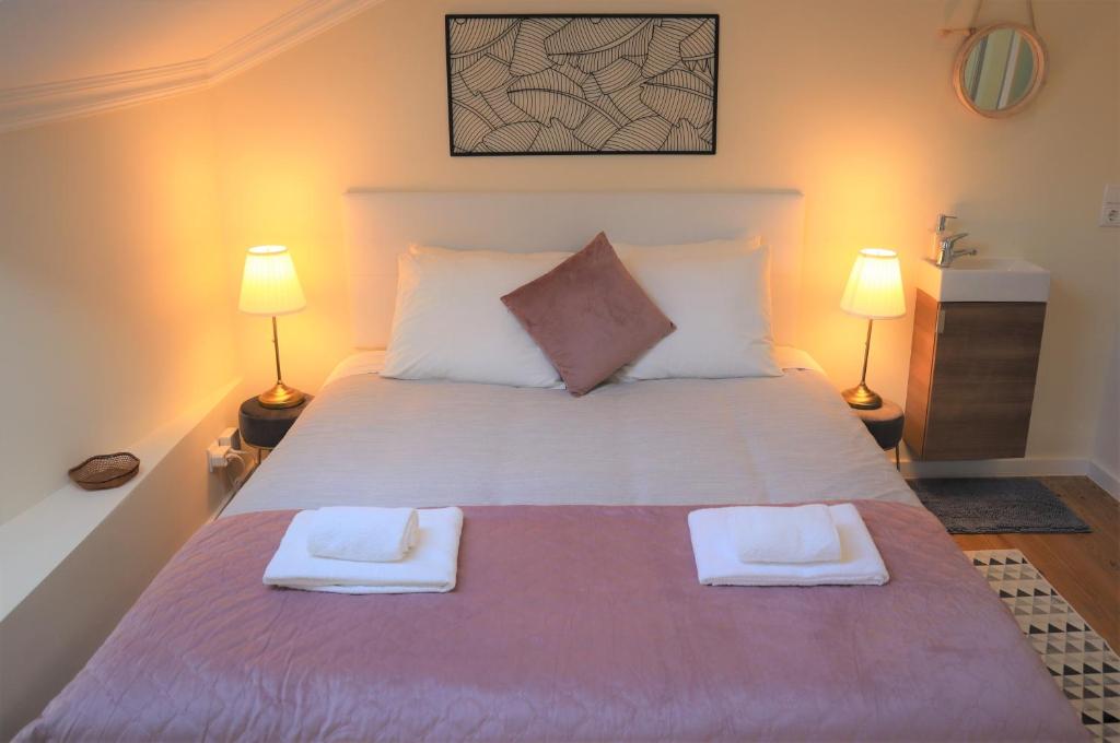 a bedroom with a large bed with two towels on it at Casa Flor do Camarão - Centro Histórico de Tomar in Tomar