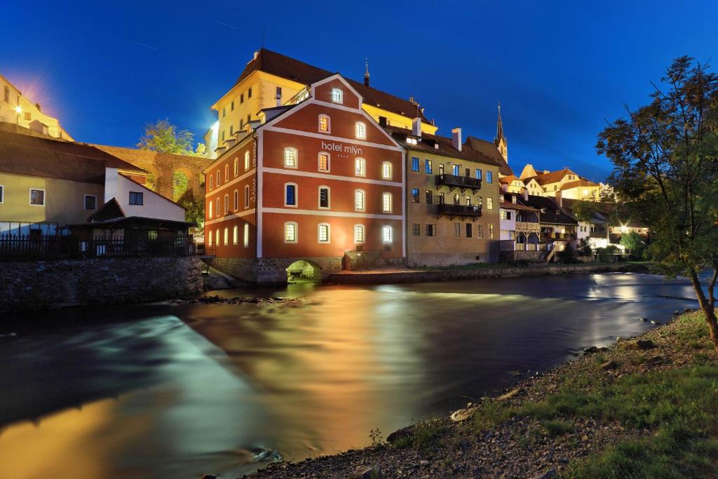 a group of buildings on a river in a city at Hotel Mlýn in Český Krumlov