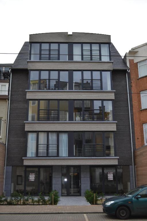 a tall black building with a car parked in front of it at Margaux in De Panne